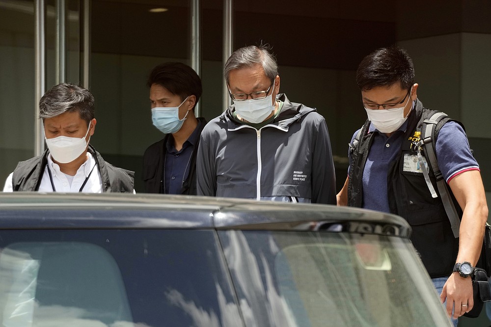 Police officers escort Cheung Kim-hung, right, CEO and Executive Director of Next Digital Ltd at Apple Daily headquarters in Hong Kong, Thursday, June 17, 2021. Hong Kong police on Thursday morning arrested the chief editor and four other senior executives of Apple Daily under the national security law on suspicion of collusion with a foreign country to endanger national security, according to local media reports. (AP Photo/Kin Cheung)