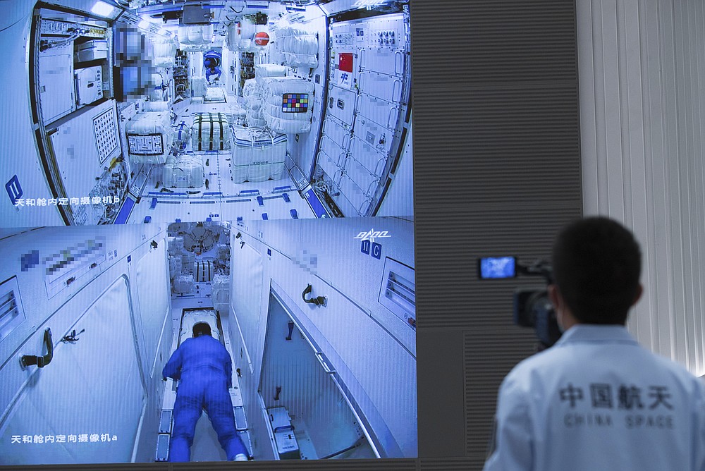 In this photo released by Xinhua News Agency, a worker monitors screens showing the interior of the Tianhe space station module after Chinese astronauts docked and enter it are displayed on large screens at the Beijing Aerospace Control Center in Beijing, on Thursday, June 17, 2021. China has launched the first three-man crew to its new space station in its the ambitious programs first crewed mission in five years (Jin Liwang/Xinhua via AP)