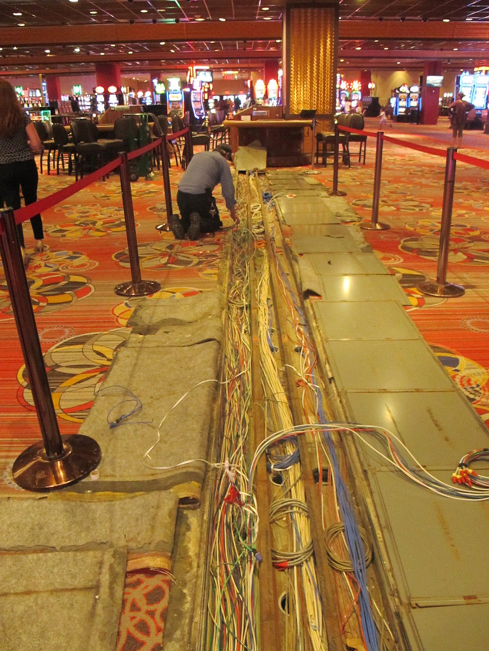 A worker inspects electrical cables on the casino floor of Bally's casino in Atlantic City N.J., Monday, June 14, 2021.  The new owners of Bally's Atlantic City are attempting to revive a comatose casino in perhaps the most cutthroat gambling market in America. Rhode Island-based Bally's Corporation is spending at least $90 million on the Boardwalk casino over the next five years, including hotel room makeovers, a renovation of the casino floor, new slot machines and restaurants, and more live entertainment.  (AP Photo/Wayne Parry)