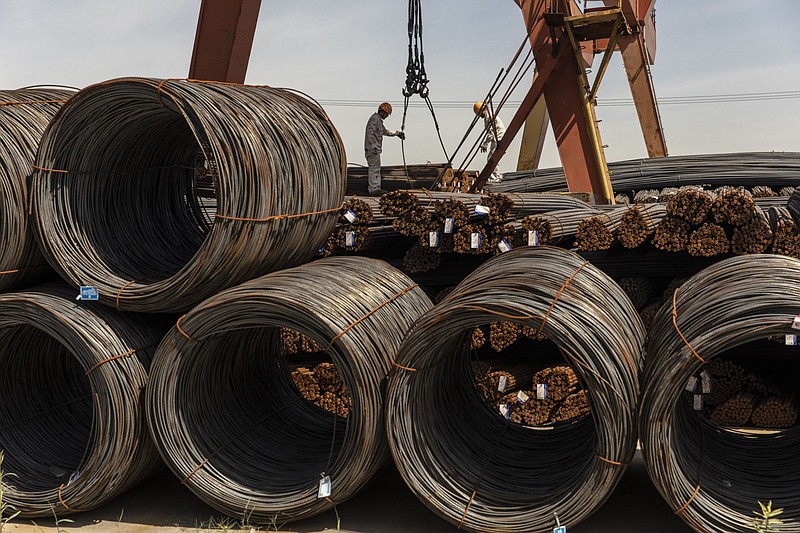 Workers prepare to lift a bundle of steel reinforcing bar with a gantry crane at a metal stock yard in Shanghai on June 7, 2021. MUST CREDIT: Bloomberg photo by Qilai Shen.