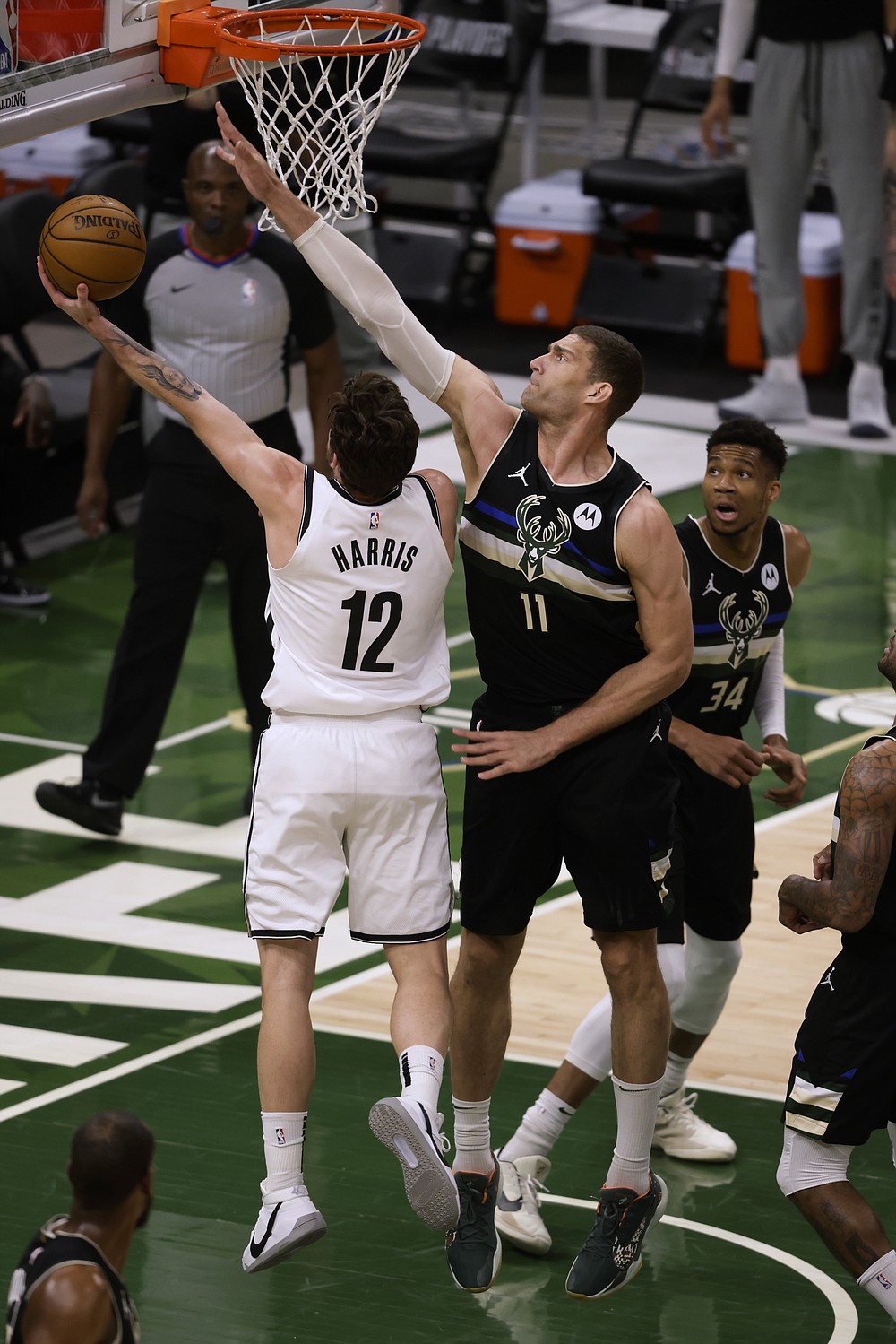 Brooklyn Nets forward Joe Harris (12) shoots next to Milwaukee Bucks center Brook Lopez (11) during the first half of Game 6 of a second-round NBA basketball playoff series Thursday, June 17, 2021, in Milwaukee. (AP Photo/Jeffrey Phelps)