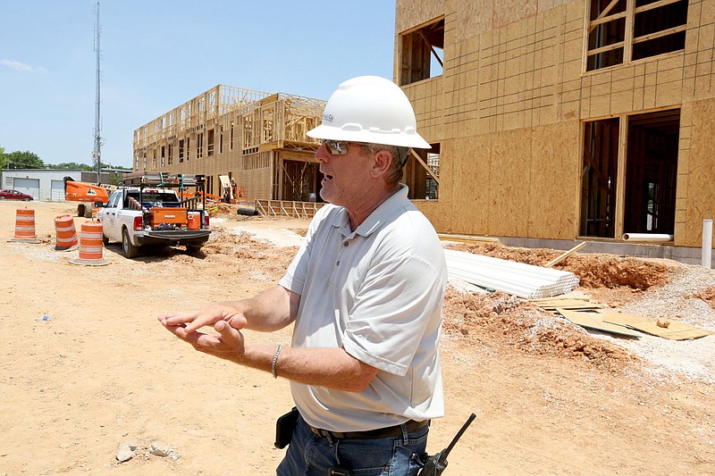 Shaun Brock, project superintendent with Huffman and Company, discusses Thursday, June 17, 2021, the underground water retention system at the South Yard as he walks through a phase of the apartment construction on the site in Fayetteville. The project lies between elements of the city's U.S. 71B corridor project to the east and the University of Arkansas Windgate Art and Design District to the west, and plans to open apartments for lease early next year. Check out nwaonline.com/210620Daily/ and nwadg.com/photos for a photo gallery.
(NWA Democrat-Gazette/David Gottschalk)