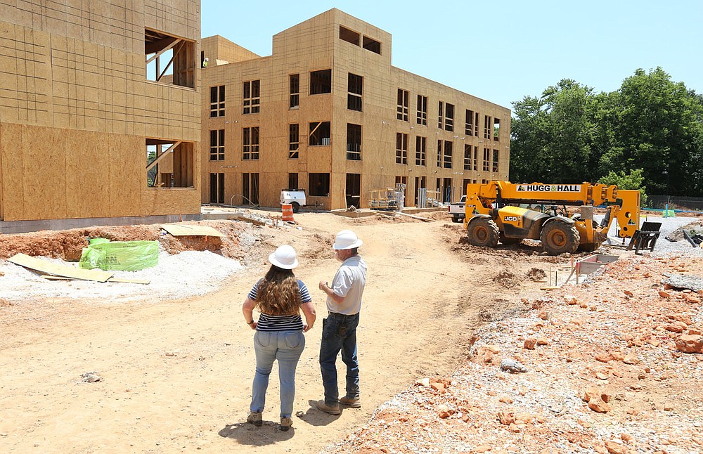 Sarah King (left), communications manager at Specialized Real Estate Group, and Shaun Brock, project superintendent with Huffman and Company, discuss the amenities Thursday, June 17, 2021, that will be available at the South Yard as they walk through a phase of the apartment construction on the site in Fayetteville. The project lies between elements of the city's U.S. 71B corridor project to the east and the University of Arkansas Windgate Art and Design District to the west, and plans to open apartments for lease early next year. Check out nwaonline.com/210620Daily/ and nwadg.com/photos for a photo gallery.
(NWA Democrat-Gazette/David Gottschalk)