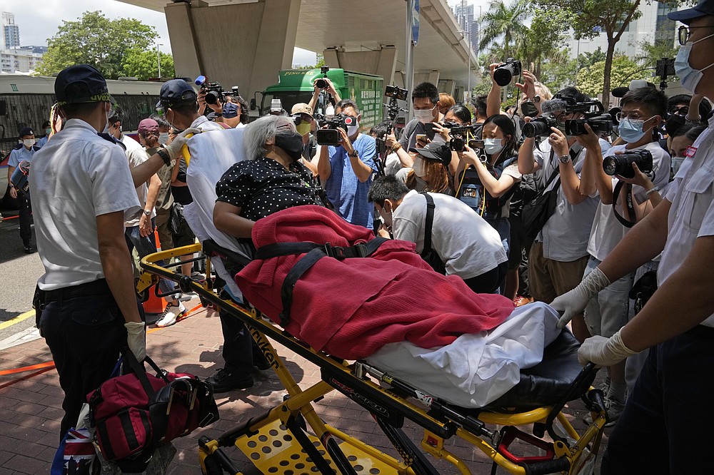 A pro-democracy protester is sent to a hospital as she feels sick outside a court in Hong Kong, Saturday, June 19, 2021. Hong Kong court ordered the top editor of pro-democracy newspaper Apple Daily and the head of its parent company held without bail Saturday in the first hearing since their arrest two days ago under the city's national security law. (AP Photo/Kin Cheung)