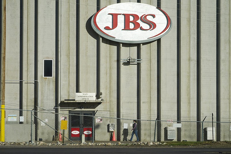 FILE - In this Oct. 12, 2020 file photo, a worker heads into the JBS meatpacking plant in Greeley, Colo. The world’s largest meat processing company says it paid the equivalent of $11 million to hackers who broke into its computer system late last month. Brazil-based JBS SA said on May 31 that it was the victim of a ransomware attack, but Wednesday, June 9, 2021 was the first time the company’s U.S. division confirmed that it had paid the ransom. (AP Photo/David Zalubowski, File)