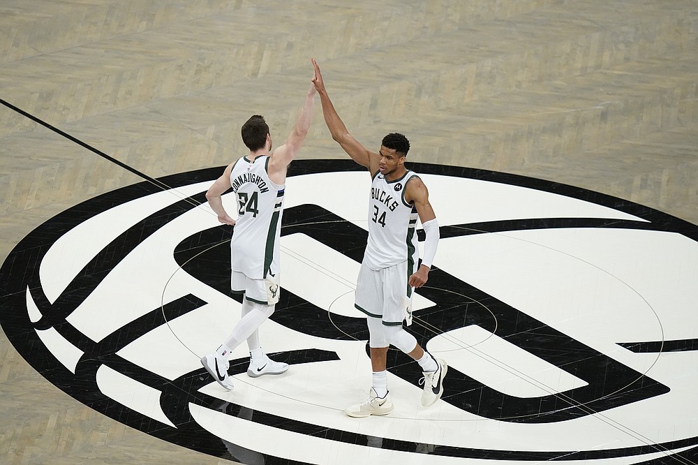 Milwaukee Bucks' Giannis Antetokounmpo (34) celebrates wth Pat Connaughton (24) after Game 7 of a second-round NBA basketball playoff series against the Brooklyn Nets, Saturday, June 19, 2021, in New York. (AP Photo/Frank Franklin II)