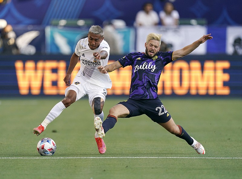 LA Galaxy defender Julian Araujo, left, battles for the ball with Seattle Sounders midfielder Kelyn Rowe during the first half of Saturday's match in Carson, Calif. - Photo by Mark J. Terrill of The Associated Press