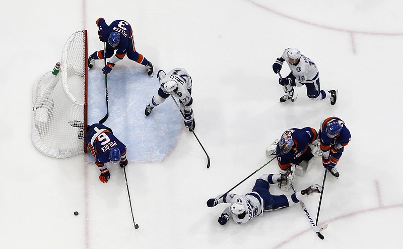 New York Islanders defenseman Ryan Pulock (6) clears the puck from the crease after a shot from Tampa Bay Lightning defenseman Ryan McDonagh (27) Saturday during the final seconds of the third period in Game 4 of a Stanley Cup semifinal in Uniondale, N.Y. - Photo by Jim McIsaac of The Associated Press