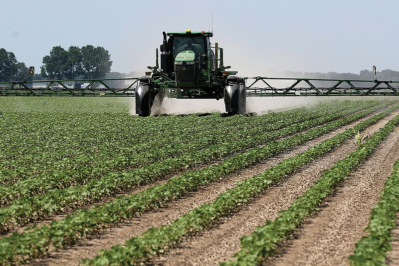 A tractor sprays insecticide on a cotton field on Friday, June 18, 2021, at Brantley Farming Company in England. 
(Arkansas Democrat-Gazette/Thomas Metthe)