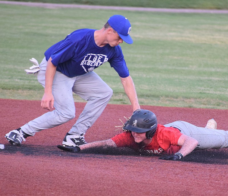 RICK PECK/SPECIAL TO MCDONALD COUNTY PRESS McDonald County's Levi Helm is out trying to stretch a single into a double during the McDonald County 18U baseball team's 18-5 win over Carthage in an 8-on-8 league game on June 16 at Joe Becker Stadium in Joplin.