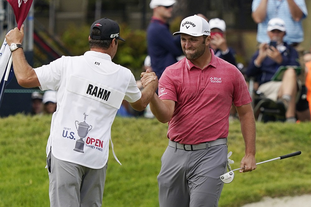 Jon Rahm, of Spain, celebrates with his caddy after making his birdie putt on the 18th green during the final round of the U.S. Open Golf Championship, Sunday, June 20, 2021, at Torrey Pines Golf Course in San Diego. (AP Photo/Marcio Jose Sanchez)