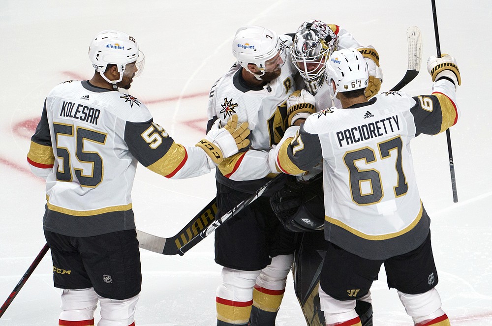 Vegas Golden Knights' Keegan Kolesar, Alex Pietrangelo and Max Pacioretty, left to right, gather around goaltender Robin Lehner to celebrate their victory over the Montreal Canadiens after overtime in Game 4 in an NHL Stanley Cup playoff hockey semifinal in Montreal, Sunday, June 20, 2021. (Paul Chiasson/The Canadian Press via AP)
