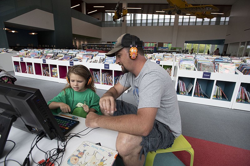 Rosie Lockett, 4, does a computer activity with her dad, Josh Lockett of Fayetteville Monday June 21, 2021 at the Fayetteville Public Library. The library has opened different pieces of its expansion over time to the public since its expansion opened. Visit nwaonline.com/2100622Daily/ and nwadg.com/photo. (NWA Democrat-Gazette/J.T. Wampler)