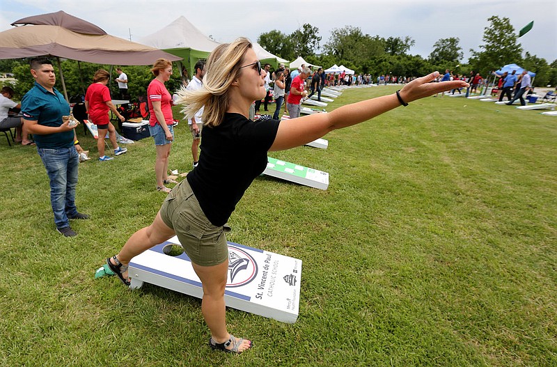 NWA Democrat-Gazette/DAVID GOTTSCHALK Megan Robison follows through on a toss Friday, June 14, 2019, during a game of Cornhole during the sixth annual Catfish, Corndogs and Cornhole tournament at Mercy Hospital Northwest Arkansas in Rogers. One hundred and twenty six team participated in the event benefited the Mercy Health Foundation.