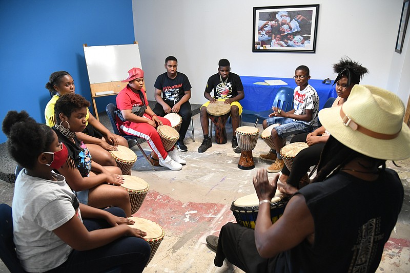 Agymah Kamau, front, right, leads a djembe drum session with Cutwell 4 Kids students. - Photo by Tanner Newton of The Sentinel-Record