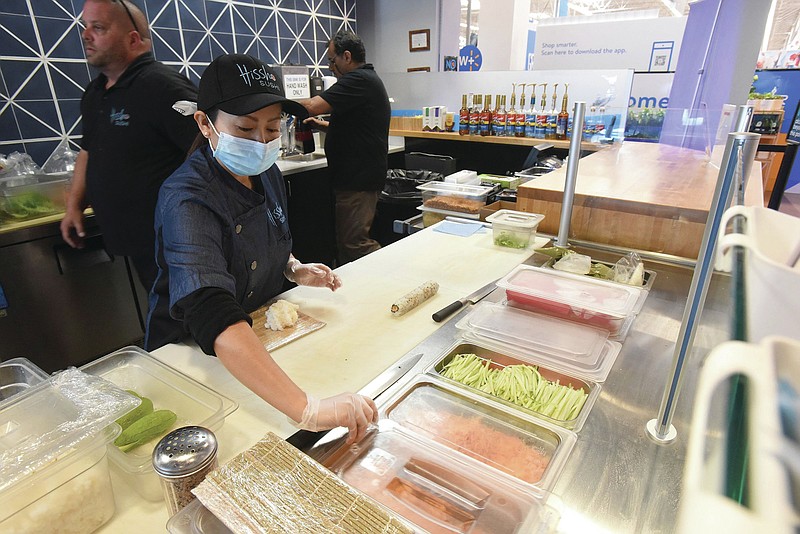 Mary Aung prepares food orders on Tuesdsay June 22 2021 at Hissho Sushi located inside the Walmart store at Pleasant Crossing shopping center in Rogers. (Go to nwaonline.com/210623Daily/ to see more photos.
(NWA Democrat-Gazette/Flip Putthoff)
