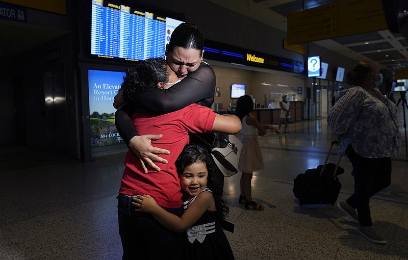 FILE - In this June 6, 2021, file photo, Emely, left, is reunited with her mother, Glenda Valdez and sister, Zuri, at Austin-Bergstrom International Airport in Austin, Texas. It had been six years since Valdez said goodbye to her daughter Emely in Honduras. Last month she caught a glimpse of a televised Associated Press photo of a little girl in a red hoodie and knew that Emely had made the trip alone into the United States. At the airport the child was returned to her mother's custody. The U.S. Homeland Security Department says thousands of asylum-seekers whose claims were dismissed or denied under a Trump administration policy that forced them to wait in Mexico for their court hearings will be allowed to return for another chance at humanitarian protection. (AP Photo/Eric Gay, File)