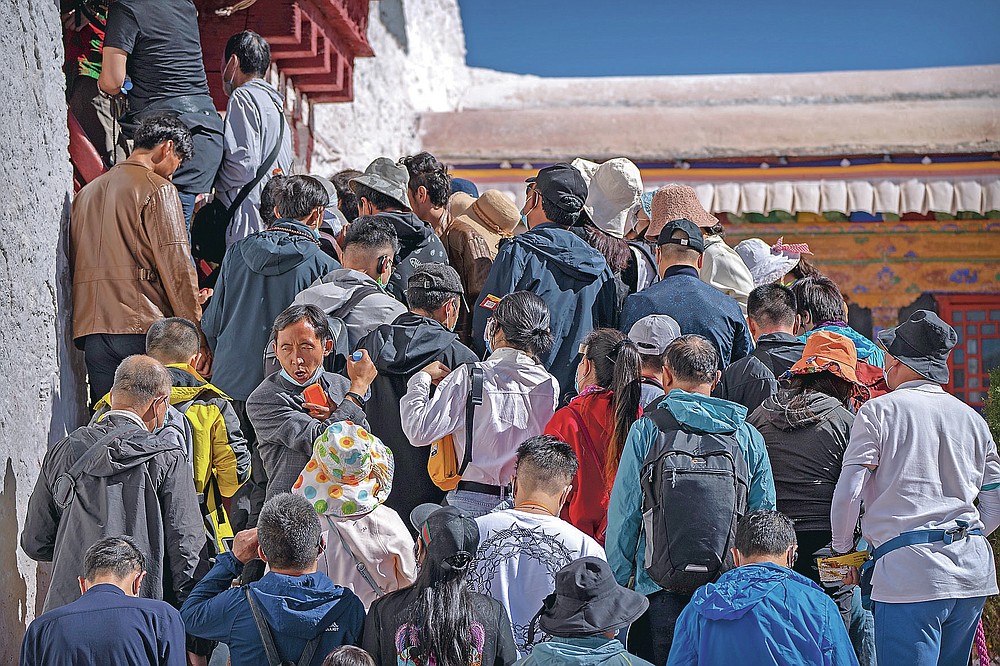 Touristen warten, um am Dienstag, den 1. Juni 2021, die Stufen zu einem Innenbereich des Potala-Palastes in Lhasa in der westchinesischen Autonomen Region Tibet zu erklimmen. Der Tourismus in Tibet boomt, da mehr Chinesen aufgrund der Coronavirus-Pandemie ins Land reisen und Risiken für die die fragile Umwelt und die historischen Stätten der Region.  (AP Foto/Mark Schiefebein)