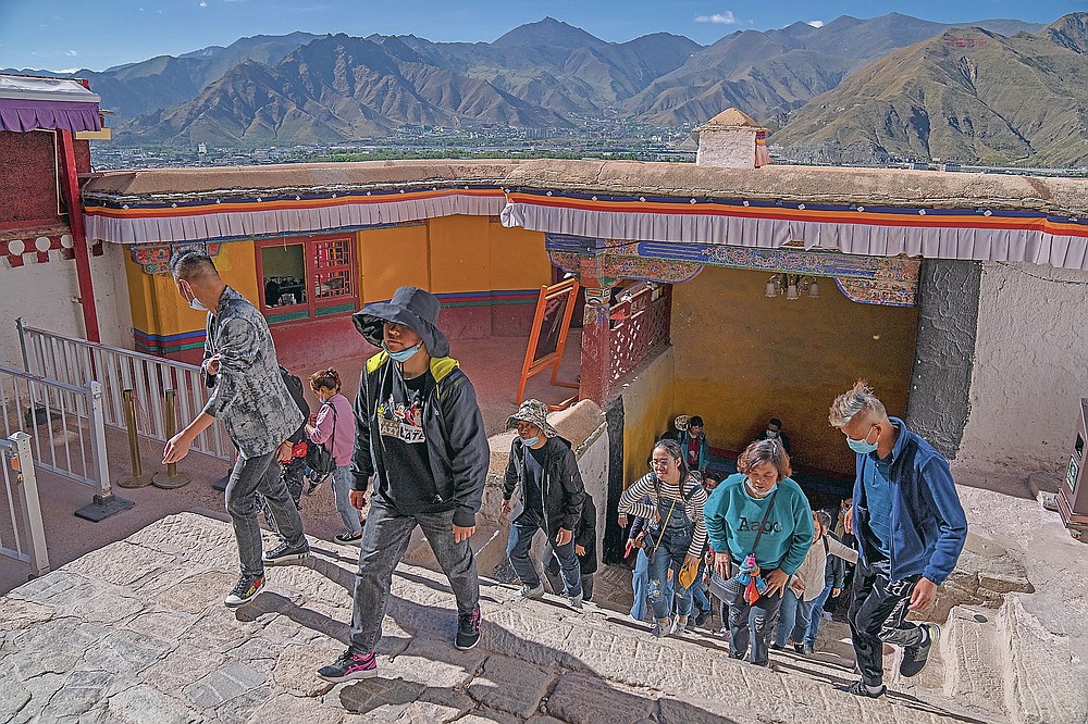 Touristen steigen am Dienstag, 1. Juni 2021, eine Treppe im Potala-Palast in Lhasa in der westchinesischen Autonomen Region Tibet hinauf. Der Tourismus in Tibet boomt, da mehr Chinesen aufgrund der Coronavirus-Pandemie ins Land reisen, was die fragile Region gefährdet Umwelt und historische Stätten.  (AP Foto/Mark Schiefebein)