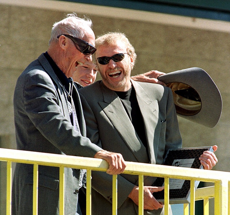 Former University of Oregon track coach Bill Bowerman shares a laugh with Nike CEO and Oregon alumni Phil Knight as Knight presents him with an award at Hayward Field during the Prefontaine Classic track meet in Eugene, Ore., in this May 30, 1999, file photo. Ever since Bowerman tinkered with the idea of pouring rubber into his waffle iron to concoct a better shoe sole for running, Nike and track have grown together. 
Photo by John Gress via The Associated Press