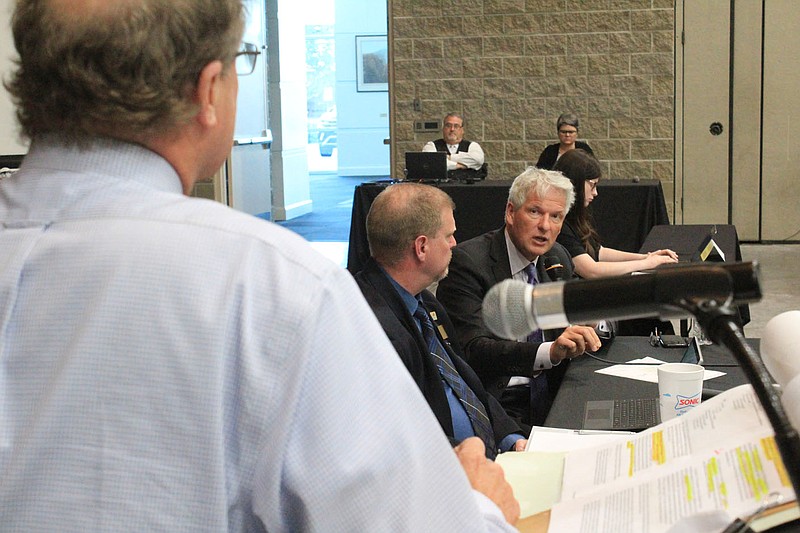 Paul Calamita, outside environmental counsel for Fort Smith, right, speaks to attorney Joey McCutchen, left, as city utility director Lance McAvoy listens Tuesday, June 22, 2021, at a consent decree update in the Fort Smith Convention Center.