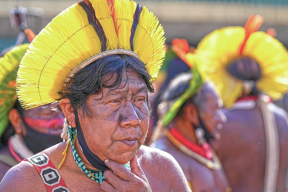 An Indigenous leader protests outside Congress in Brasilia, Brazil, Wednesday, June 23, 2021. Indigenous activists have traveled to the capital to demand government action to halt illegal mining and logging on their reservations and oppose a proposed bill they say would limit recognition of tribal lands. (AP Photo/Ricardo Mazalan)