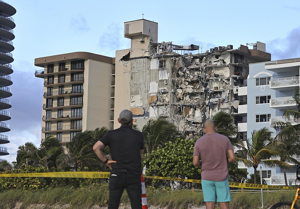 People look at the partially collapsed Champlain Towers South Condo in Surfside, Florida on Thursday, June 24, 2021 (David Santiago / Miami Herald via AP)