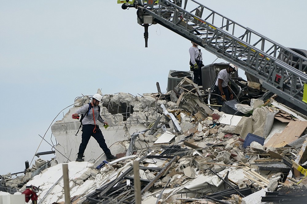 Rescue worker walk among the rubble where a wing of a 12-story beachfront condo building collapsed, Thursday, June 24, 2021, in the Surfside area of Miami. (AP Photo/Lynne Sladky)
