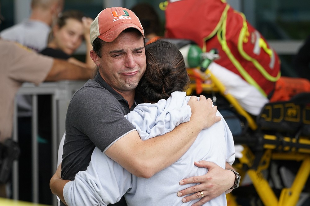 A couple kiss while awaiting news from the survivors of a collapsed condominium on Thursday, June 24, 2021 in Surfside, Florida.  Dozens of survivors have been withdrawn and rescuers continue to look for more.  (AP Photo / Marta Lavandier)
