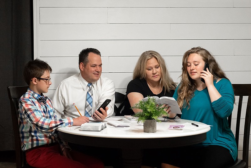 Evan Parsons (from left), his parents, Chad and Sarah Parsons, and sister Abbi Parsons make phone calls to reach the public with a message of faith in lieu of knocking on doors during the coronavirus pandemic. The Parsonses, who live in Searcy, are among the 1.7 million Jehovah’s Witnesses in the U.S. who have shifted away from the longtime practice of meeting people face to face to evangelize.
(Special to the Democrat-Gazette)