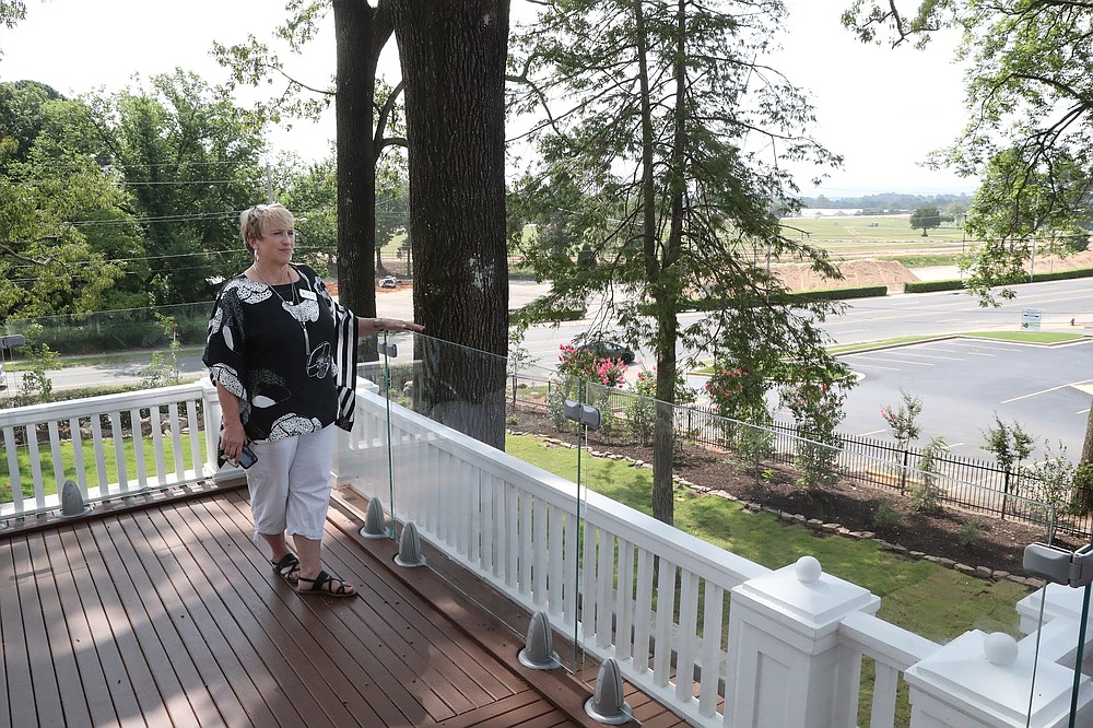 Rhonda McMurry enjoys the view from The Reserve at Hot Springs’ second-floor veranda. - Photo by Richard Rasmussen of The Sentinel-Record