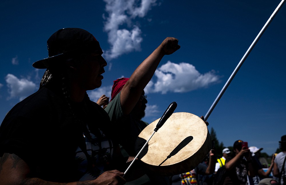 Roy Broncheau, aka Walks Through Hail, plays the drum and sings during a march, on Monday, June 7, 2021, in Clearwater County, Minn. More than 2,000 Indigenous leaders and "water protectors" gathered in Clearwater County from around the country to protest the construction of Enbridge Line 3. The day started with a prayer circle and moved on to a march to the Mississippi headwaters where the oil pipeline is proposed to be built. (Alex Kormann/Star Tribune via AP)