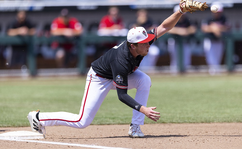 North Carolina State's Sam Highfill misses the throw to first base, allowing Vanderbilt's Dominic Keegan to reach on an error, in the fourth inning during a baseball game in the College World Series, Friday, June 25, 2021, at TD Ameritrade Park in Omaha, Neb. (AP Photo/Rebecca S. Gratz)