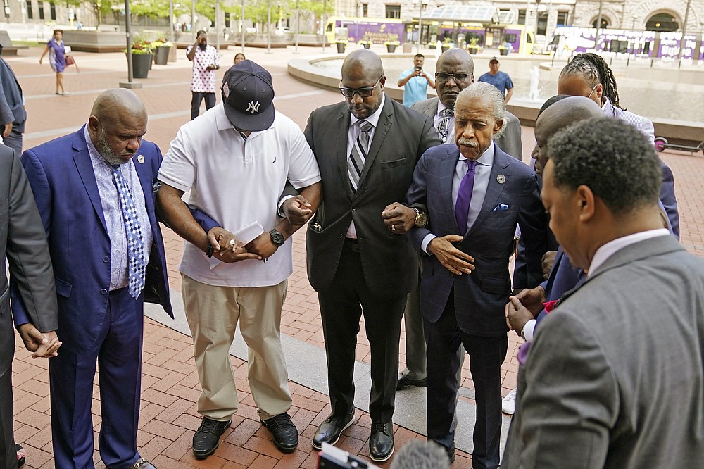 The Rev. Al Sharpton, right, with hand on coat, along with family members of George Floyd leads a prayer before entering the Hennepin County Government Center for the sentencing of former Minneapolis police officer Derek Chauvin, Friday, June 25, 2021, in Minneapolis, for the May 2020 death of George Floyd during an arrest in Minneapolis. (AP Photo/Jim Mone)