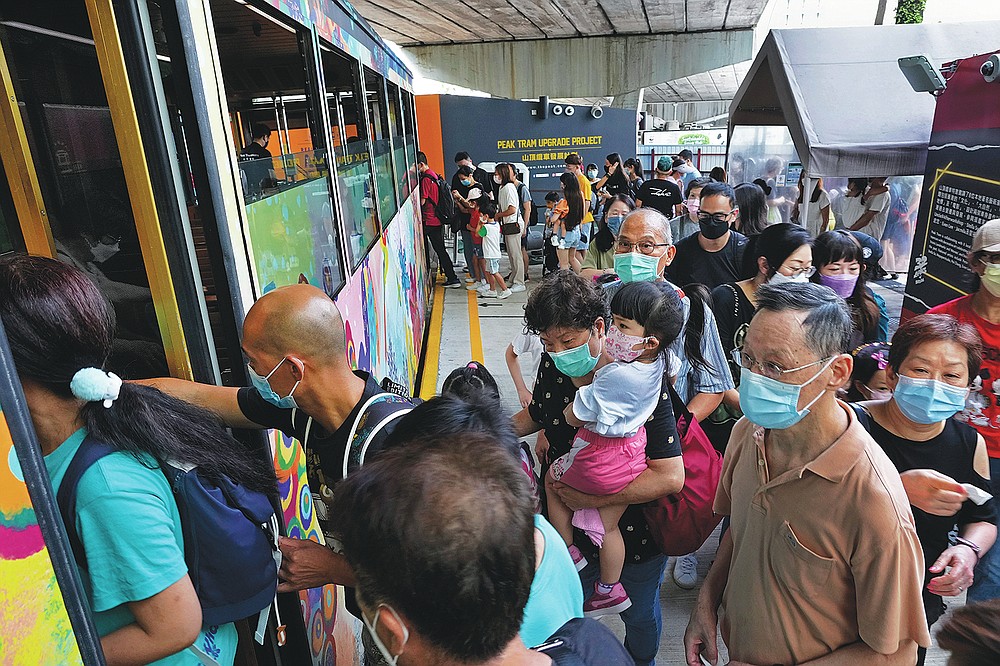 Passengers board a Peak Tram in Hong Kong on June 17, 2021. The Hong Kong Peak Tram is a staple in the memory of many residents and tourists, carrying passengers to Victoria Peak for a bird's-eye view of the many skyscrapers in the city. (AP Photo / Vincent Yu)