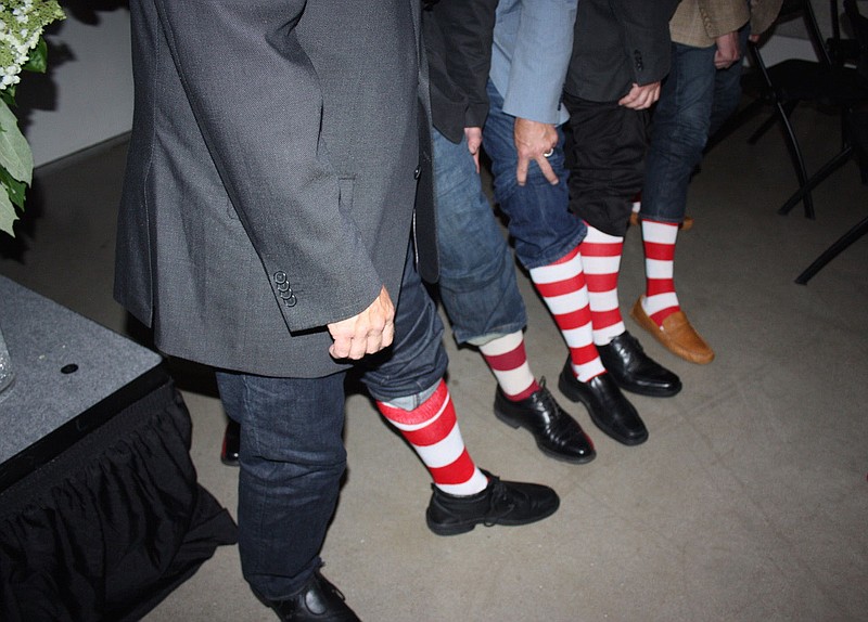 NWA Democrat-Gazette/CARIN SCHOPPMEYER Guests at the Red Shoe Soiree on May 29 display their striped socks in support of Ronald McDonald House Charities.