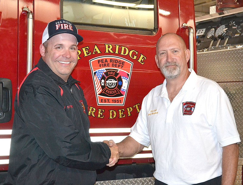 Outgoing Fire Chief Jack Wassman, right, congratulates Jared Powell who was named interim fire chief of the Pea Ridge Fire-EMS Department.
