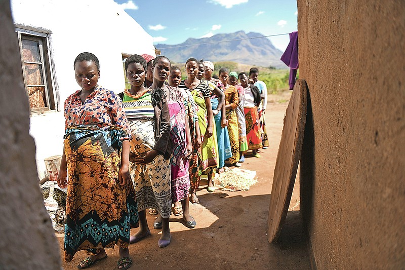 Pregnant women queue to see Lucy Mbewe, a traditional birth attendant at her home in Simika Village, Chiradzulu, southern Malawi, Sunday, May 23, 2021. Health officials in Malawi say fewer women are getting prenatal care amid the COVID-19 pandemic. At risk are the developing country's gains on its poor rate of maternal deaths. (AP Photo/Thoko Chikondi)