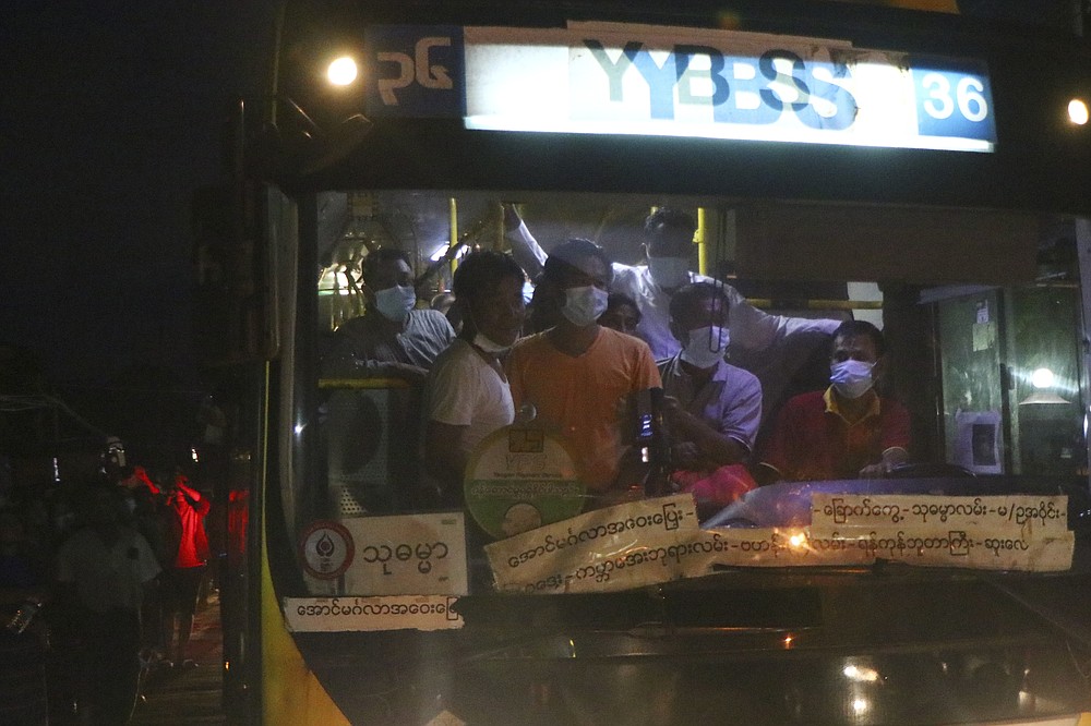 A bus with released prisoners onboard is driven out of Insein Prison in Yangon, Myanmar Wednesday, June 30, 2021. Myanmar's government began releasing about 2,300 prisoners on Wednesday, including activists who were detained for protesting against the military's seizure of power in February and journalists who reported on the protests, officials said.  (AP Photo)