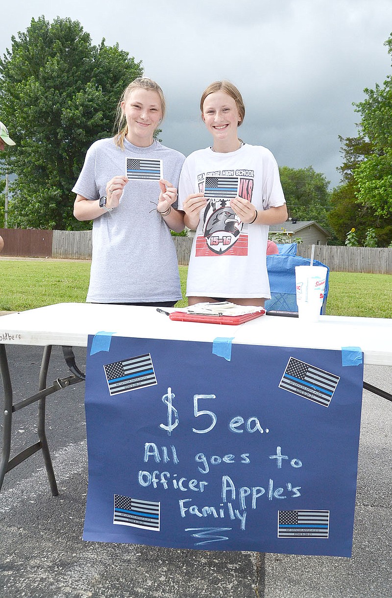 Kasey and Reigh-Anne Goldberg, sisters, were selling decals of blue-line flags honoring Officer Kevin Apple. The girls, and their parents, Sean and Tammy Goldberg, said all proceeds are being given back to the Pea Ridge Fraternal Order of Police.