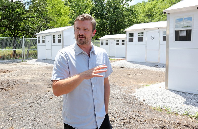Solomon Burchfield, director of New Beginnings, describes Tuesday, June 29, 2021, the new cabins at New Beginnings located south of 19th Street and South School Avenue in Fayetteville. The plans for New Beginnings involve 20 prefabricated houses with about 140 square feet of living space, with a 2,800-square-foot community building to provide clients basic needs. Check out nwaonline.com/210704Daily/ and nwadg.com/photos for a photo gallery.
(NWA Democrat-Gazette/David Gottschalk)