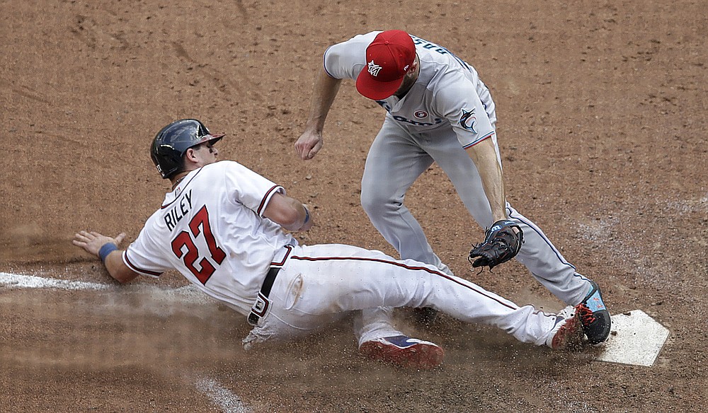 Atlanta Braves designated hitter Orlando Arcia is mobbed by