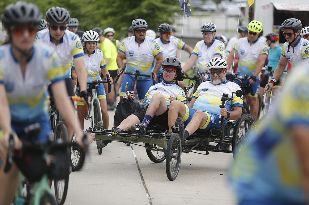 Josh Fohner leaves Shiloh Square with his father Mike Thursday, July 1, 2021, and teammates, friends and well wishers en route to Lewis and Clark Outfitters in Springdale. Fohner, the inspiration behind the All In For Josh Ride, was finishing up a 908 mile bicycle ride that started in Buena Vista, CO. to Springdale. The Springdale native was seriously injured in a biking accident in 2016 and suffered severe brain injuries. Check out nwaonline.com/210702Daily/ and nwadg.com/photos for a photo gallery.(NWA Democrat-Gazette/David Gottschalk)
