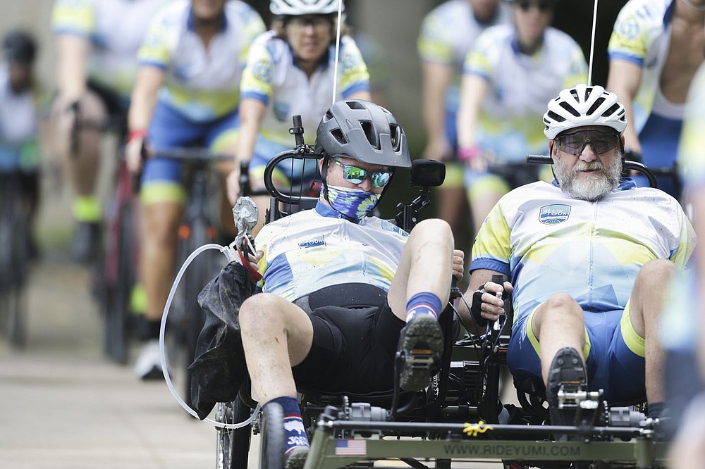 Josh Fohner (from left) and his father Mike Fohner ride, Thursday, July 1, 2021 along the greenway through the Horsebarn trailhead in Rogers. The All in for Josh ride ended its 908-mile journey with the Ride for Hope from Bentonville to Springdale. The ride started in Buena Vista, Colo. in June and finishes in Springdale at Lewis and Clark. Josh Fohner is a Springdale native who was seriously injured in a biking accident in 2016 and suffered severe brain injuries. This ride is a fundraiser for the Fohner family to continue Josh's rehabilitation efforts. Check out nwaonline.com/210702Daily/ for today's photo gallery.
(NWA Democrat-Gazette/Charlie Kaijo)