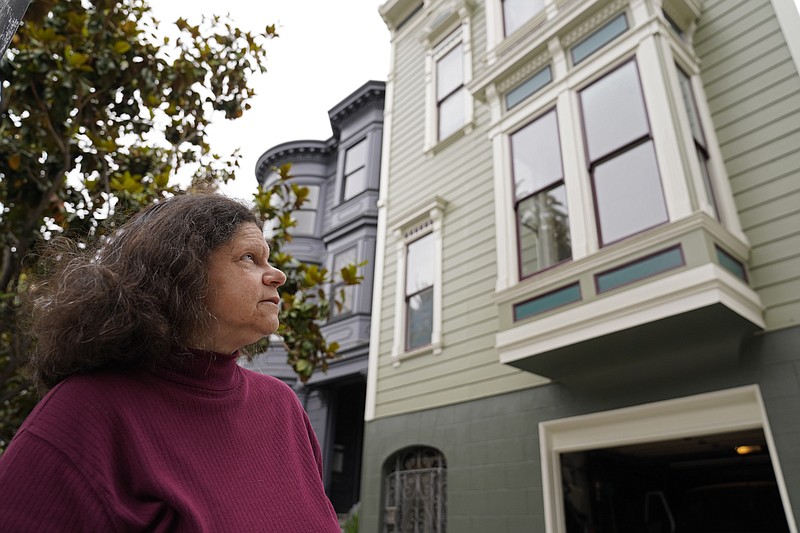 Census taker Linda Rothfield looks up at an apartment building she was unable to access in San Francisco, on Wednesday, June 30, 2021. Some census takers worry that renters in apartment buildings were not tallied fully during the nation's head count last year. Census takers say they had difficulty entering apartment buildings due to COVID restrictions, and they weren't able to get in touch with landlords for help. (AP Photo/Eric Risberg)