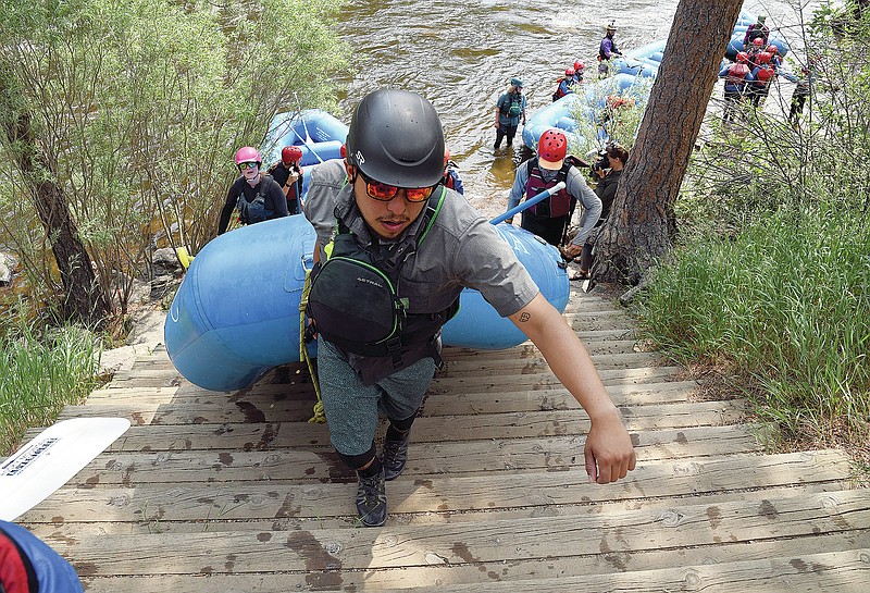 Kevin Perez, a rafting guide for Rocky Mountain Adventures, pulls an inflatable boat out of the water after taking a group down the Cache la Poudre River near Fort Collins, Colo., Wednesday, June 23, 2021. The river in northern Colorado is flowing well compared to waterways in the western part of the state, much of which is experiencing extreme drought. (AP Photo/Thomas Peipert)