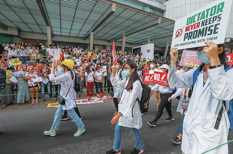 FILE - In this Thursday, Feb. 25, 2021 file photo, doctors, supporters of the "Civil Disobedience Movement," participate in a march against the military's seizure of power in Yangon, Myanmar. Protests by medics started days after the military ousted democratically elected leaders from power. The response from the military was fierce, with security forces beating medical workers and stealing supplies. (AP Photo/File)