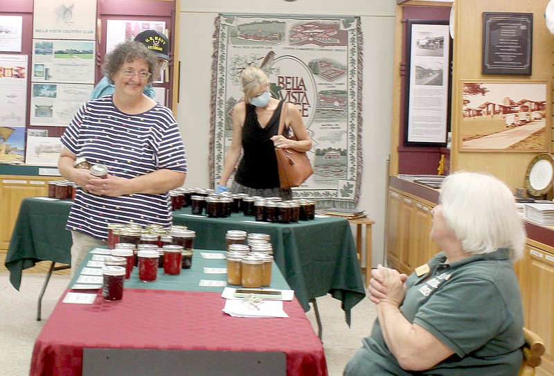 Keith Bryant/The Weekly Vista
Angie Rader, left, talks with Jill Werner, seated, during a jam giveaway fundraiser for the Bella Vista Historical Museum.