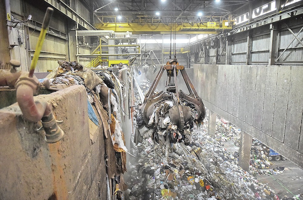 Operators control large grappling hooks to move garbage into a chute where the waste falls into the incinerator to burn during a tour of the Lancaster County Solid Waste Management Authority's waste-to-energy facility in Bainbridge, Pa., on Wednesday, June 16, 2021. (Suzette Wenger/LNP/LancasterOnline via AP)