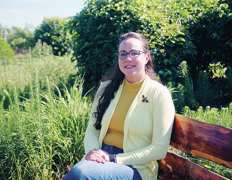 Nicole Muszynski, assistant professor of psychology at Hastings College, poses for a photo in the Rain Garden, Wednesday, June 23, 2021 in Hastings, Neb. Growing up in Texas and Hawaii, Nichole Muszynski was never abuzz about bees. So it is as much a surprise to the 32-year-old psychology professor as it is to all who know her that she now finds them so becoming. (Amy Roh/The Hastings Tribune via AP)